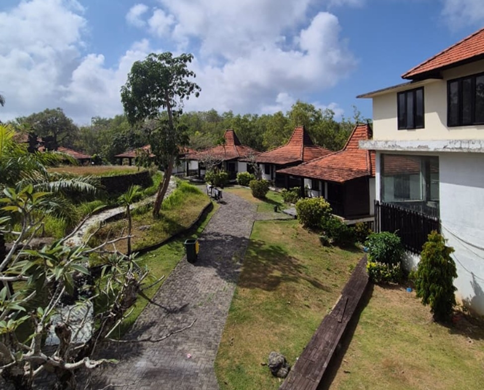 Melasti freehold plot, Bali: paved path between existing pavilions and a two-storey building