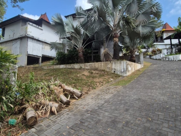 Freehold land in Melasti, Bali: paved driveway beside an existing building on the plot